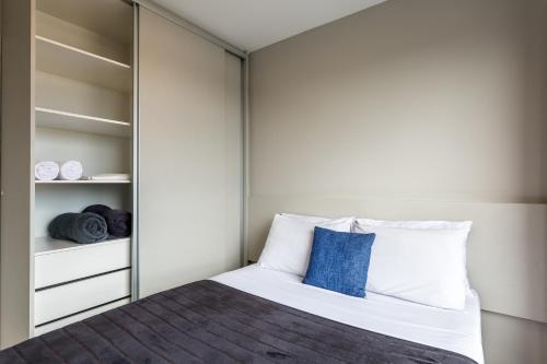 a bedroom with a bed and a closet at Pleione Flats in Curitiba