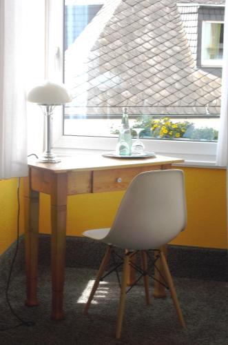 a desk with a lamp and a chair in front of a window at Hotel Trabener Hof in Traben-Trarbach