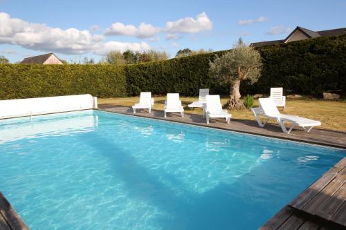une piscine avec des chaises longues et une piscine dans l'établissement Contemporary Villa of Kerseal, à Gouesnach
