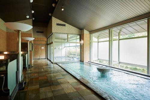 um quarto grande com piscina no meio do chão em Oushuku Onsen Choeikan em Shizukuishi