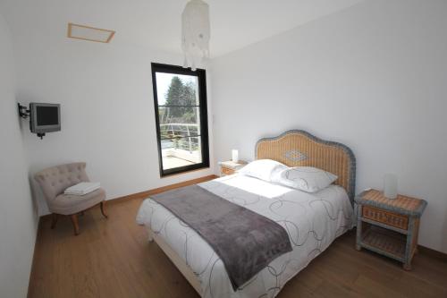 Un dormitorio con una cama grande y una ventana. en Contemporary Villa of Kerseal, en Gouesnach