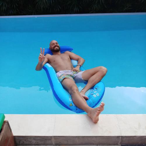 a man laying on a raft in a swimming pool at 2 Home in Chalong 