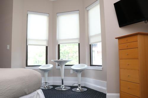 a bedroom with windows and a bed with two stools at Stylish Downtown Studio, #32 in Boston