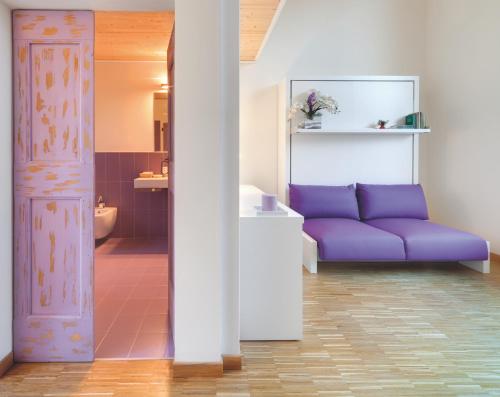 a living room with a purple couch and a bathroom at Il Portico in Fano