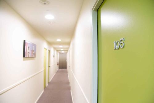 a hallway with a green door in a hospital at City Lodge Accommodation in Auckland