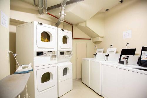 a laundry room with washing machines and a counter at City Lodge Accommodation in Auckland
