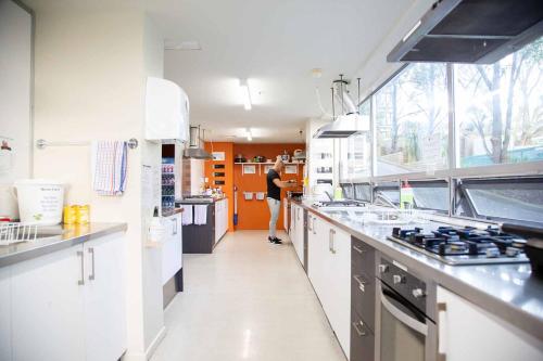 uma mulher está de pé numa grande cozinha em City Lodge Accommodation em Auckland