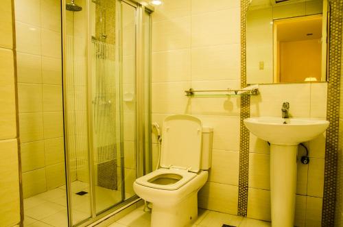 a bathroom with a shower and a toilet and a sink at Dreamwave Hotel Santiago in Santiago City