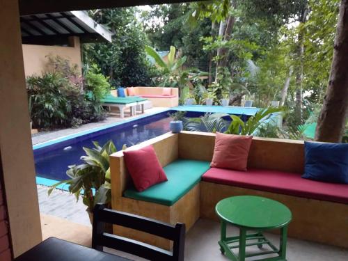 a patio with a couch and a table and a pool at Randoni Villa in Raddoluwa