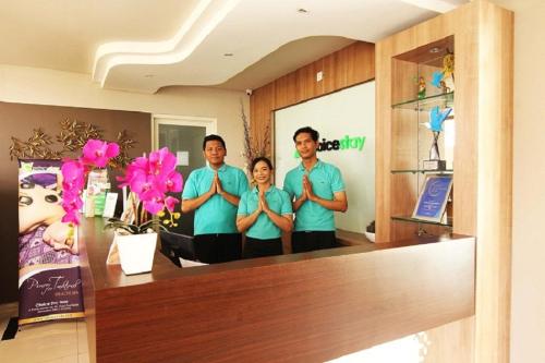 a group of three people doing yoga in a room at Choice Stay Hotel Denpasar in Denpasar