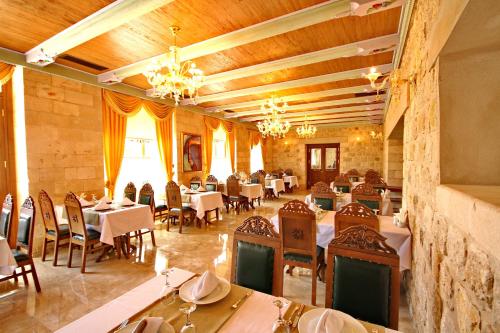 a dining room with tables and chairs and chandeliers at Izala Boutique Hotel in Mardin