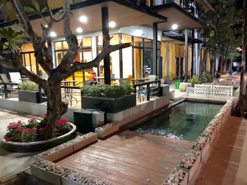 a swimming pool with a tree in the middle of a building at The C Hotel in Amnat Charoen