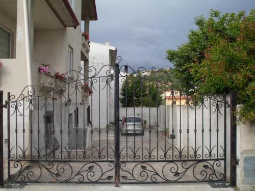 a gate to a house with a car behind it at Affittacamere Peonia in Oliena