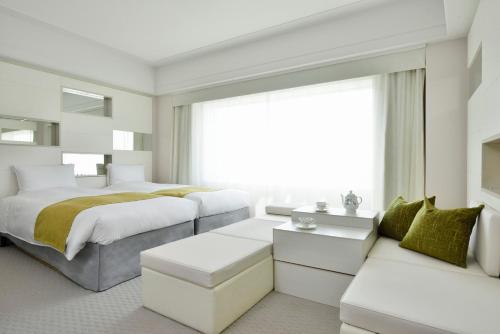 a white bedroom with a bed and a couch at Urayasu Brighton Hotel Tokyo Bay in Urayasu