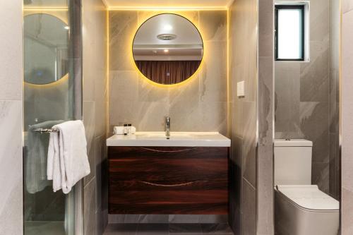 a bathroom with a sink and a toilet and a mirror at Opal Ridge Motel in Collinsville