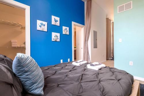 a bedroom with a blue wall and a bed at Trifecta Spacious & Beautiful Wifi Superhost in Charlotte