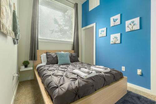 a blue bedroom with a bed with towels on it at Trifecta Spacious & Beautiful Wifi Superhost in Charlotte