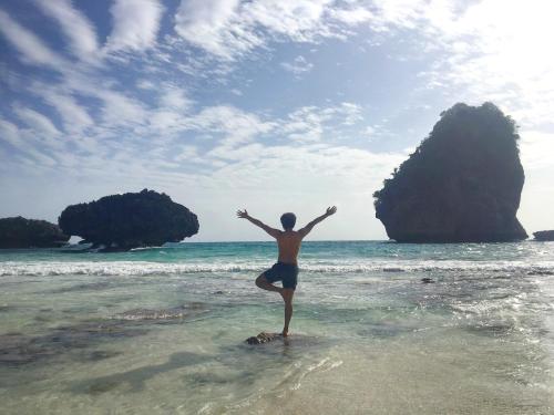 a man standing in the water on the beach at Phi Phi Maiyada Resort in Phi Phi Don