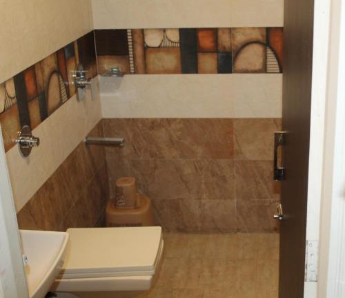 ein Bad mit einem WC und einem Waschbecken in der Unterkunft Choice Classic Hotel in Pune