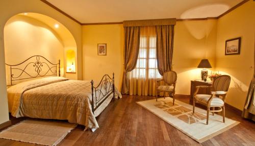 a bedroom with a bed and a desk and a window at Tenuta Cusmano in Grottaferrata