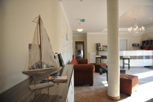 a living room with a model boat on a counter at Ostseehotel Boltenhagen in Boltenhagen