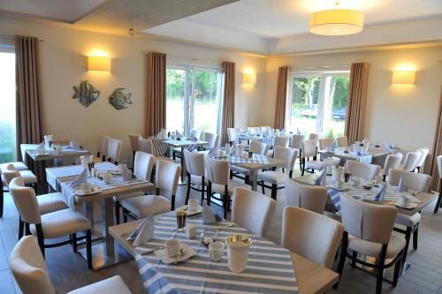 a dining room filled with tables and chairs at Ostseehotel Boltenhagen in Boltenhagen