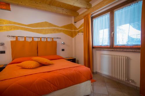una camera con un letto arancione e una finestra di La Casa Del Grillo 2 ad Aosta