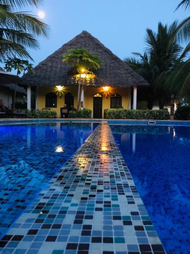 a swimming pool at night with a resort at Kiwengwa Bungalow Boutique Resort in Kiwengwa