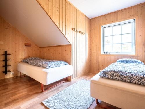 two beds in a room with wood paneling at XLyngen in Nord-Lenangen
