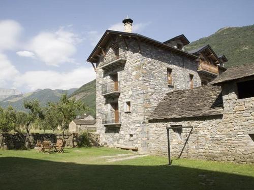 an old stone building with a chimney on top of it at Apartamentos Casa Buisan in Broto