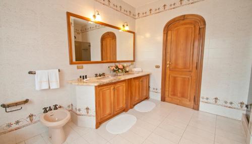 a bathroom with a toilet and a sink and a mirror at Tenuta Cusmano in Grottaferrata