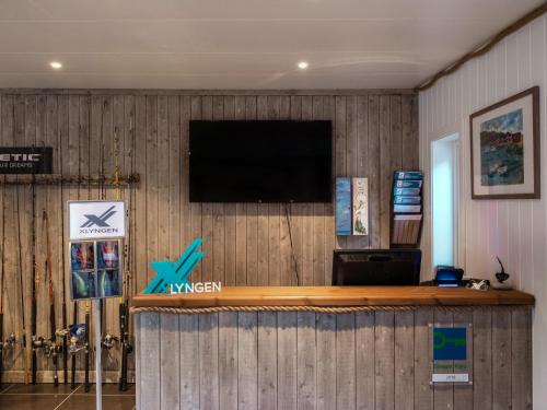 a bar with a tv on a wooden wall at XLyngen in Nord-Lenangen