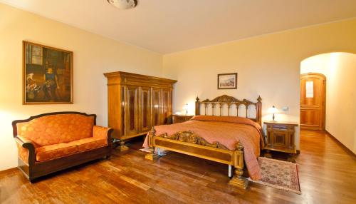 a bedroom with a bed and a chair in it at Tenuta Cusmano in Grottaferrata