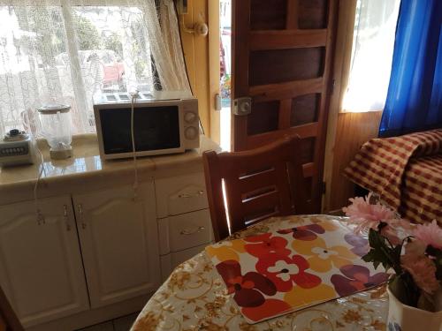 a kitchen with a table and a microwave on a counter at Cabañas Patricia Licanray in Licán Ray
