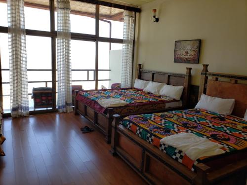 a bedroom with two beds and a large window at Top Twelve Hotel - Lalibela in Lalībela