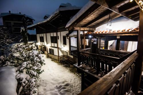 a house covered in snow at night with lights at Banskovilla Zlateva House in Bansko