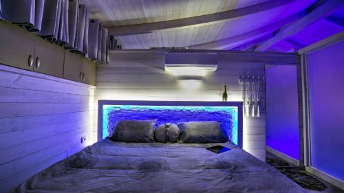 een bed in een kamer met paarse verlichting bij Olimpos Eilat in Eilat