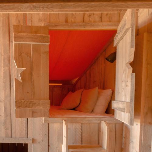 a wooden bed inside of a wooden house at HolaCamp Sitges Garrofer in Sitges