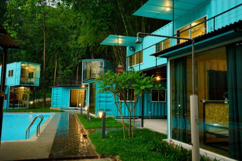 a building with a swimming pool next to a house at Sarang by the brook in Kuala Kubu Baharu