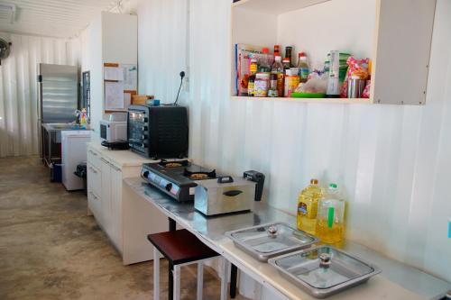 eine Küche mit einer Theke mit 2 Waschbecken und einer Mikrowelle in der Unterkunft Sarang by the brook in Kuala Kubu Baharu