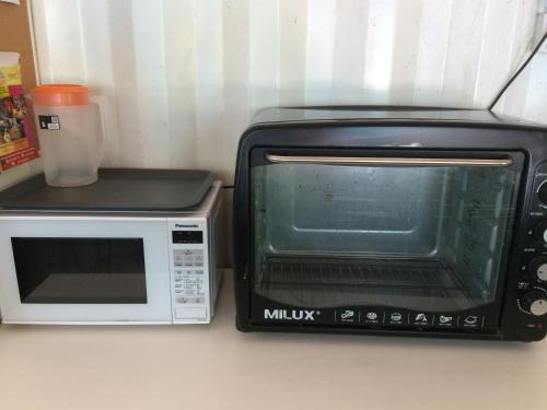 a microwave and a toaster oven on a counter at Sarang by the brook in Kuala Kubu Baharu