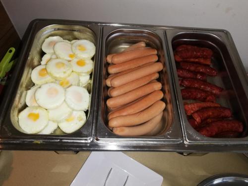 a tray of food with eggs sausage and sausages at Hotel Klar in Liptovský Mikuláš