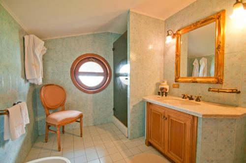a bathroom with a sink and a mirror and a chair at Tenuta Cusmano in Grottaferrata
