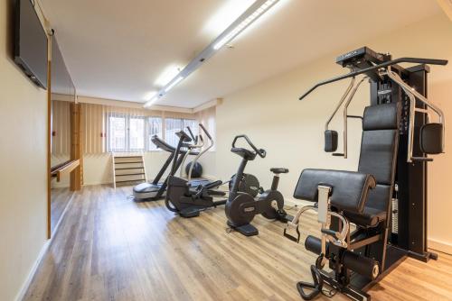 a gym with treadmills and exercise equipment in a room at Mercure Antwerp City South in Antwerp