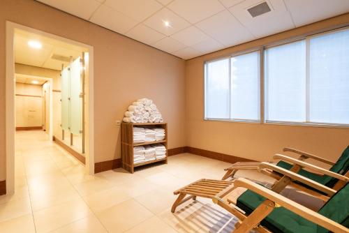 a waiting room with rocking chairs and towels at Mercure Antwerp City South in Antwerp