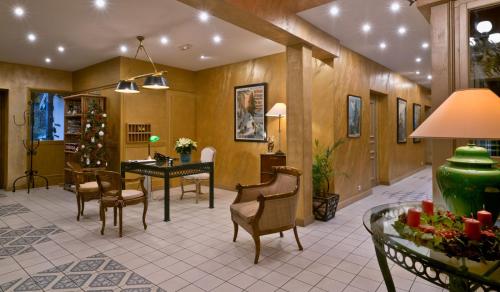 a lobby with chairs and a table with a christmas tree at Le Manoir Au Lac in Gérardmer