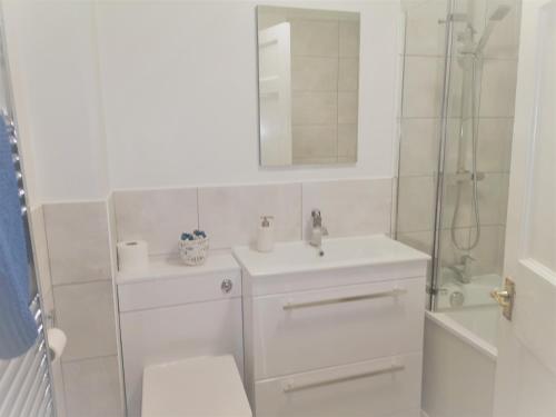 Un baño con inodoro, lavabo y ducha. en Heritage City - Central York Place Apt, en Edimburgo