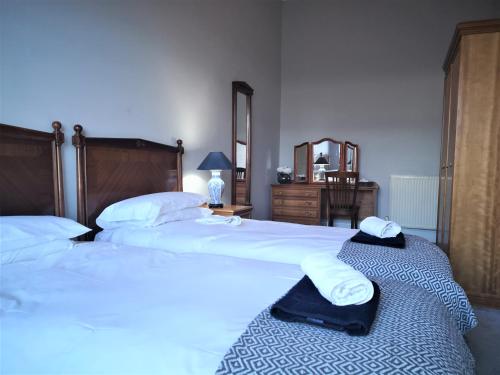 Un dormitorio con dos camas con sábanas blancas y toallas. en Heritage City - Central York Place Apt, en Edimburgo
