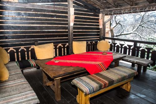a table and chairs on a porch with a red napkin at Banskovilla Zlateva House in Bansko