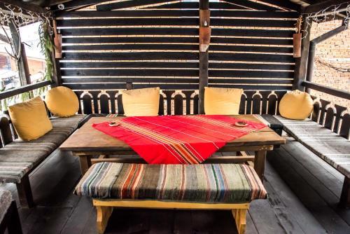 a wooden table with chairs and a red napkin on it at Banskovilla Zlateva House in Bansko